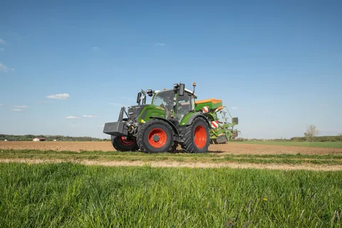 Ein grüner Fendt 300 Vario transportiert eine Drillkombination vom Feld.