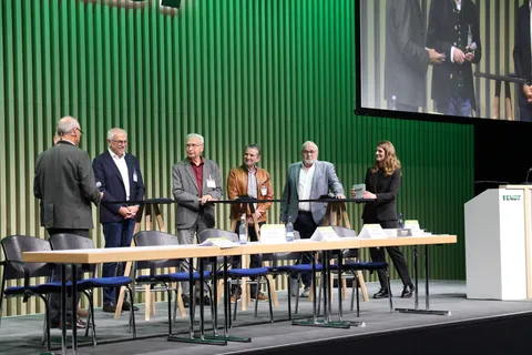 Teilnehmer der Podiumsdiskussion stehen auf der Bühne im Fendt Global Forum in Marktoberdorf