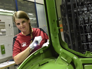 Fendt Mitarbeiterin steht neben Fendt Schlepper mit Taschenlampe in der Hand