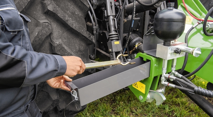 Eine Person legt ein Werkzeug in die ausgezogene Werkzeugschublade am Fendt Cutter.