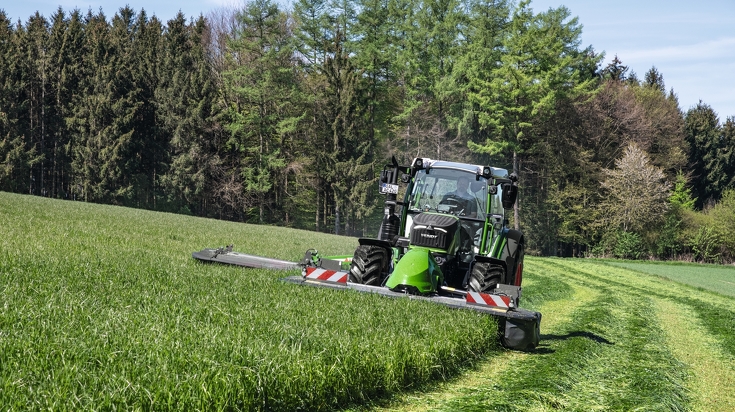 Fendt 516 Vario mit Fendt Slicer 310 F und Heckmähwerkanbau mäht bei schönem Wetter eine Wiese