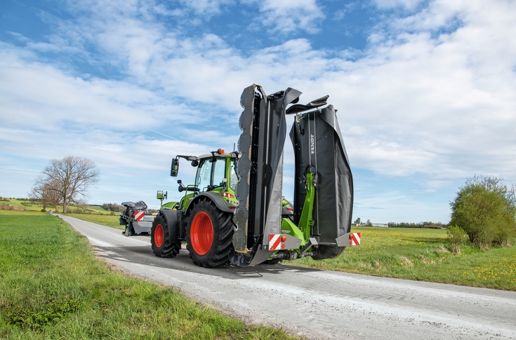 Fendt Traktor mit Fendt SafetySwing zur EInklappung des Fendt Slicer 860 fährt auf einer Straße