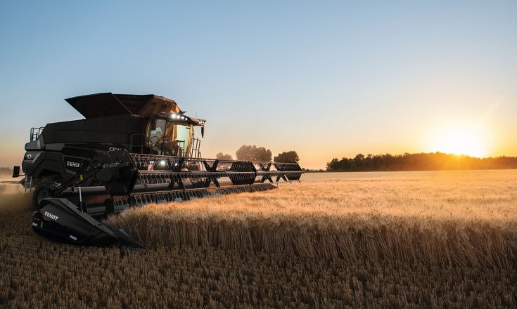 Feld Ideal 10T Mähdrescher beim Drusch eines Feldes bei untergehender Sonne