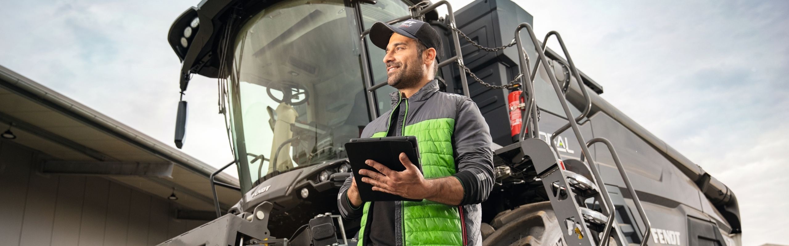 Ein schwarzer IDEAL Mähdrescher auf dem Hof eines Händlers mit einem Fendt Profi im Vordergrund