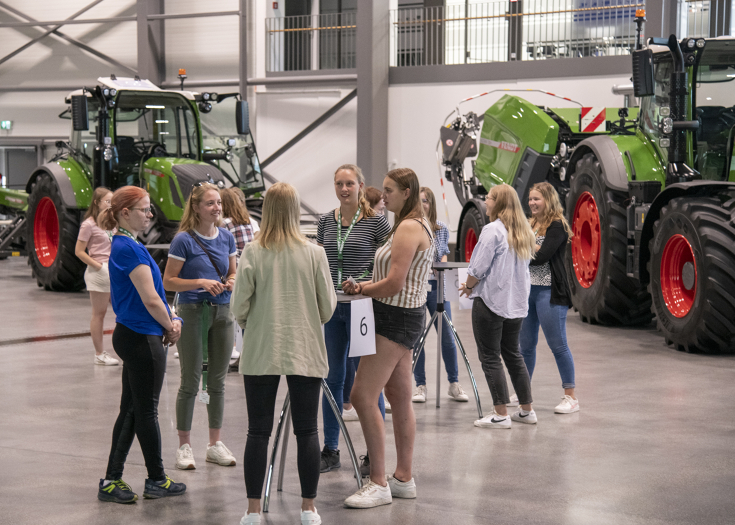 Junge Frauen bei Fendt Frauenkarrieretag Eine Gruppe junger Frauen an Stehtischen im Fendt Produktforum