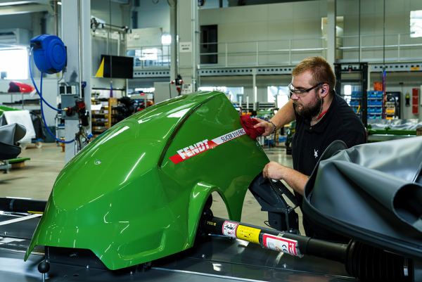 Ein Fendt Mitarbeiter montiert etwas an einer Fendt Slicer Haube.