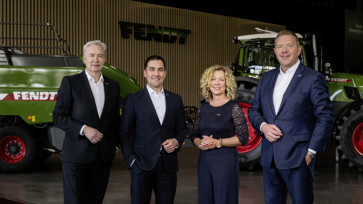 Die Geschäftsführung von Fendt Von links nach rechts stehen die Geschäftsführer Ekkehart Gläser, Dr. Josef Mayer, Ingrid Bußjäger-Martin und Christoph Gröblinghoff nebeneinander im Fendt Forum vor einem Fendt Traktor und der Fendt Quaderballenpresse