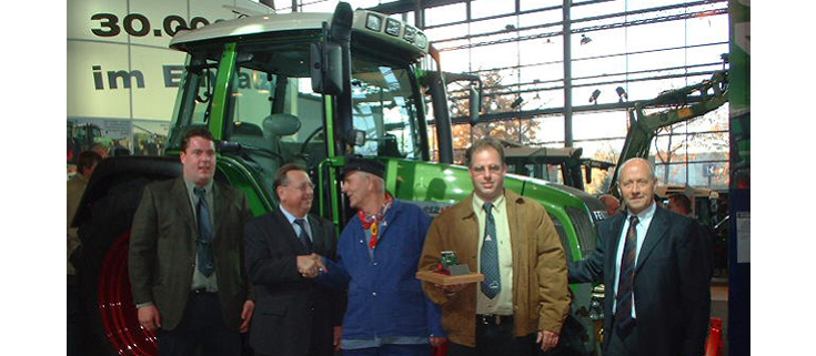 Auslieferung des 30.000sten Fendt Schleppers an die Niederlanden im Jahr 2013 5 Männer vor einem Fendt Farmer 412 Vario bei der Auslieferung des 30.000sten Fendt Schleppers an die Niederlanden im Jahr 2013, der dritte Mann von links mit niederländischer Tracht - blaue Kleidung, Schiebermütze und ein rotes Halstuch
