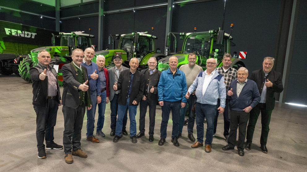 13 ehemalige Fendt Mitarbeiter vor Fendt Traktoren auf der Fendt Ehemaligenfeier 2025 13 Männer stehen vor drei grünen Fendt Traktoren und zeigen den Daumen hoch.