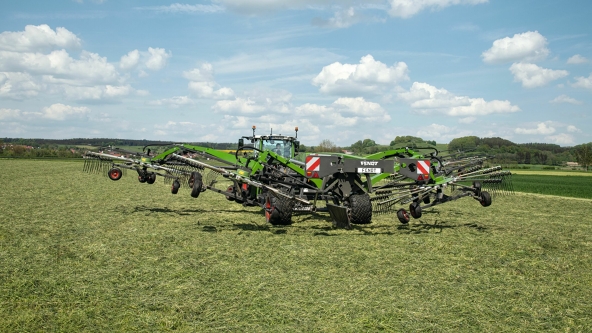 Sicht auf ein grünes Feld, auf dem der Fendt Former 14055 PRO eine Testfahrt zum Schwaden vorführt