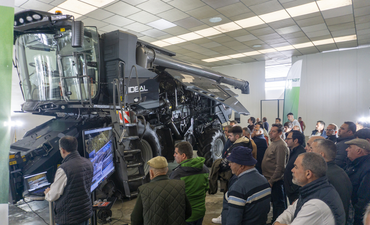 Fendt IDEAL 7 PL Rotor-Mähdrescher Eine Gruppe von Landwirte schaut unter das aufgeklappte Seitenteil eines Fendt Fendt IDEAL 7 PL Rotor-Mähdreschers in einer Halle