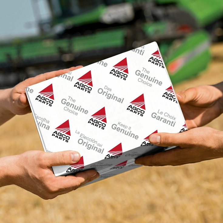 Übergabe eines AGCO Parts Paketes auf dem Feld.