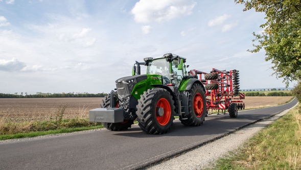 Ein Fendt 1000 Vario auf einer Landstraße neben einem Feld