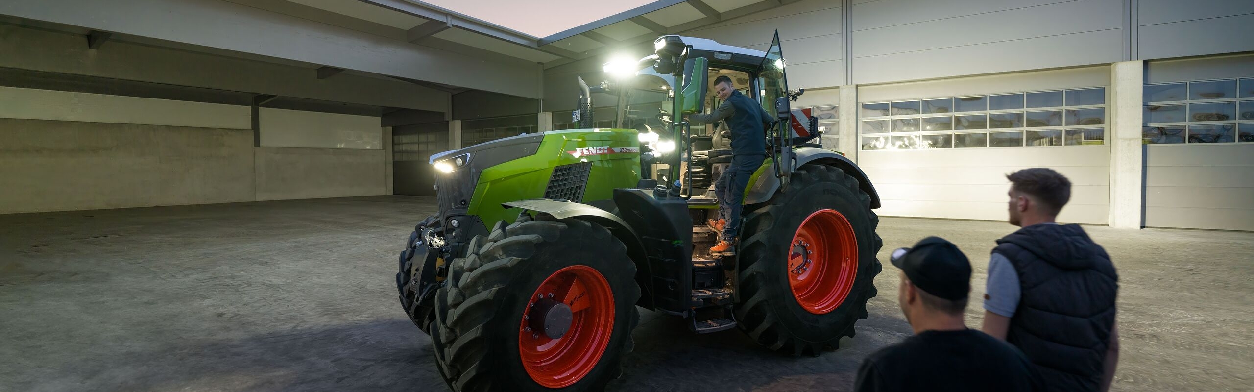 Sicht in den Innenhof eines Lohnunternehmers, der für seine Fahrer den Fendt 800 Vario Traktor mit voller Beleuchtung bereitstehen hat