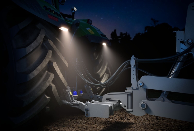 Fendt 1000 Vario mit GroundVison Das Heck eines grünen Fendt 1000 Vario in einer Halle fotografiert, die Deichselbeleuchtung GroundVision an den Kotflügeln ist eingeschaltet.
