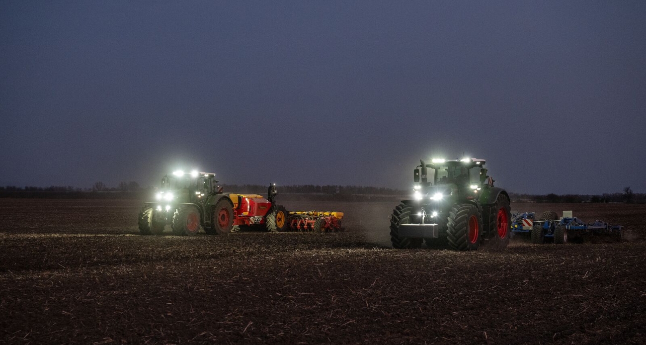 Ein grüner Fendt 1000 Vario mit Grubber und ein grüner Fendt 800 Vario mit Sämaschine von Väderstad arbeiten gemeinsam auf einem Feld. Die Zusammenarbeit funktioniert über den Datenaustausch in der FendtONE Funktion  Fendt Workgroup.