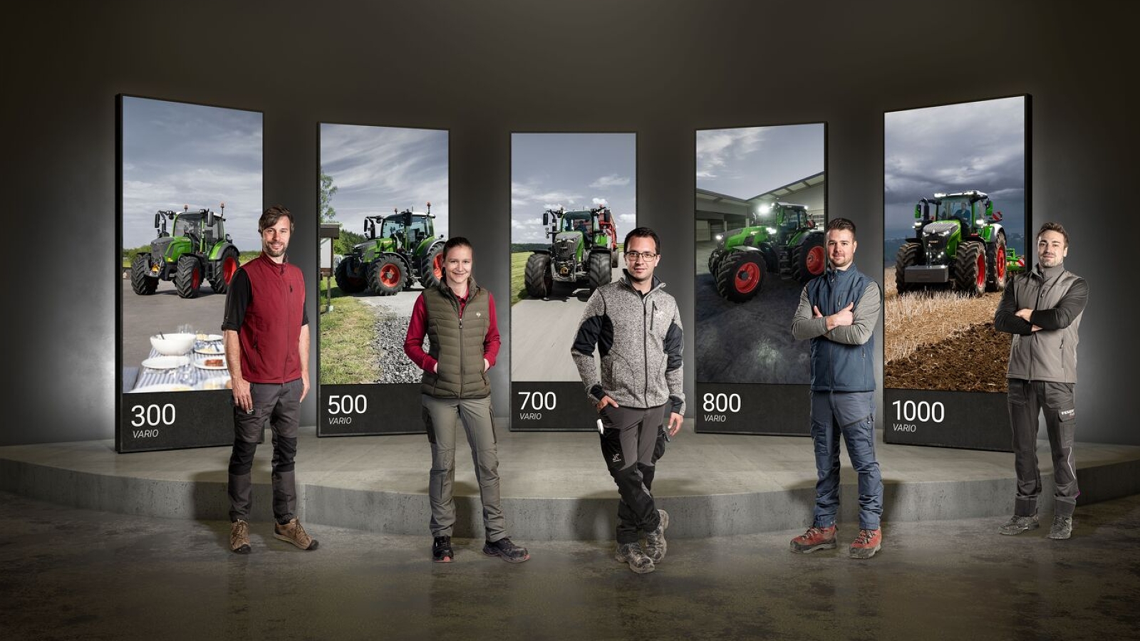 Fendt 300, 500, 700, 800 und 100 Vario 5 Personen stehen nebeneinander, hinter Ihnen große Bildschirme mit jeweils dem Fendt 300, 500, 700, 800 und 100 Vario.