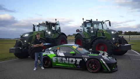Clay Osborne standing in front of two green Fendt tractors and his Porsche racing car with the Fendt logo
