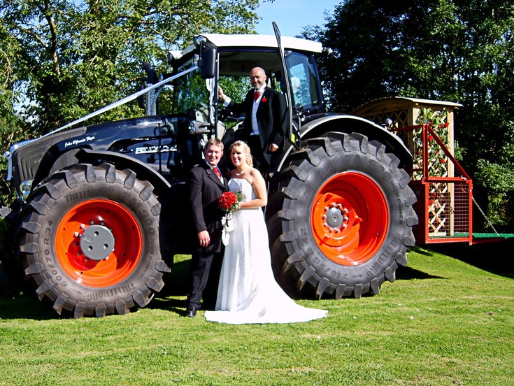 The proud father Alan with his daughter Becky and her husband James in front of the "Black Beauty" Fendt Vario 936