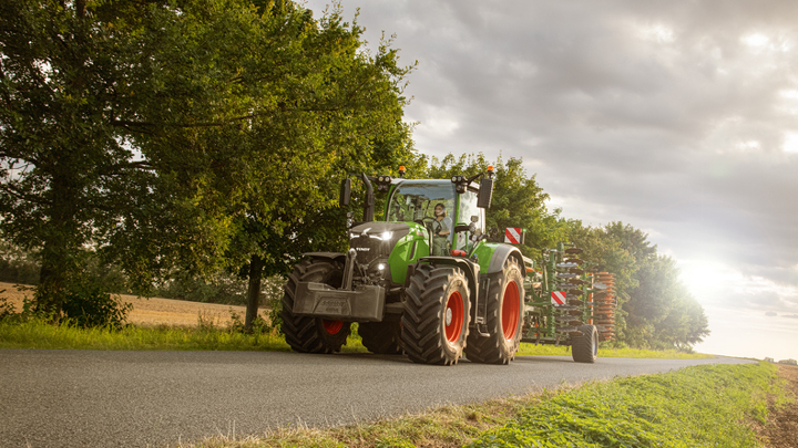 A female farmer drives the Fendt 700 Vario Gen7 on the road.