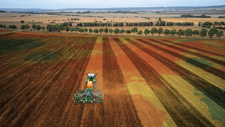 A green Fendt tractor with implement for precise tillage thanks to FendtONE machine control
