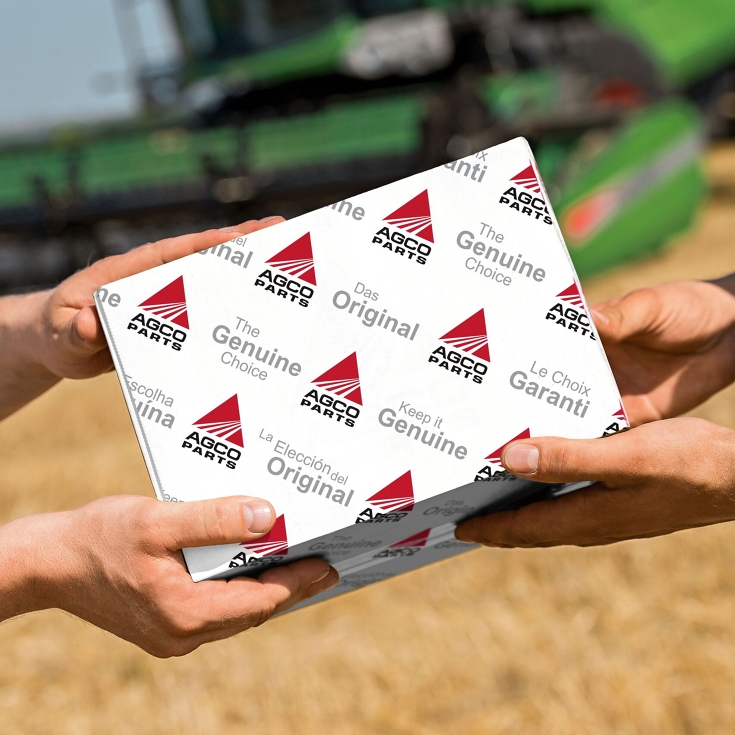 Handover of an AGCO Parts package in the field.
