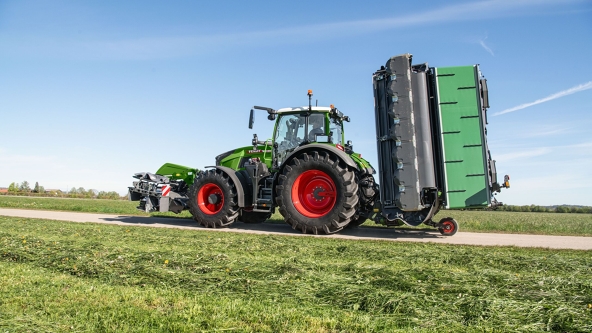 Fendt tractor with an attached transporter on a dirt path
