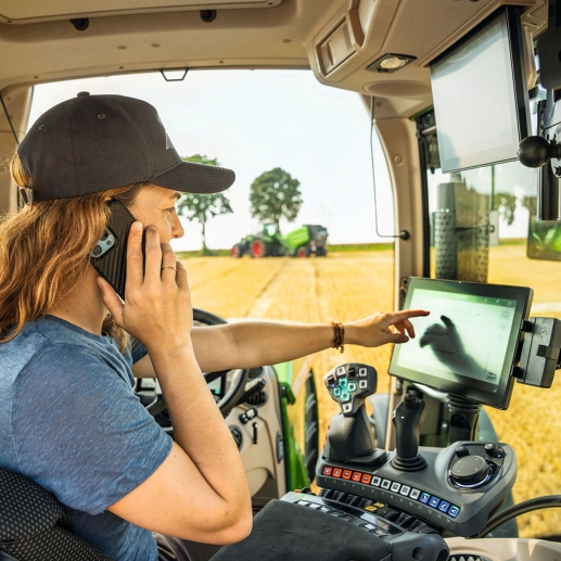 Uma agricultora liga para seu revendedor da Fendt da cabine do trator.