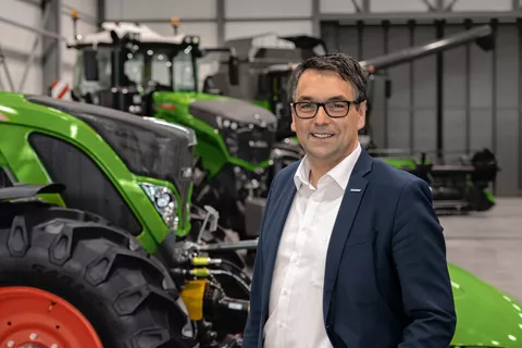 Roland Schmidt (Vice President Fendt Marketing) vor einer Reihe von Fendt Traktoren