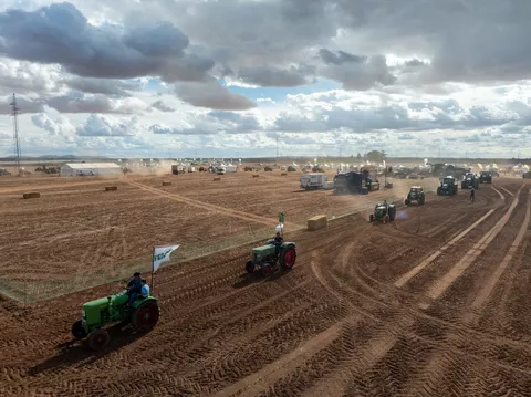Eine Parade an Fendt Traktoren fährt mit Fahnen