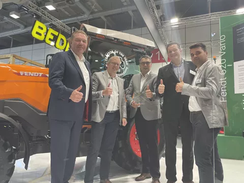 5 Männer: Christoph Gröblinghoff, Karsten Köhler, Roland Schmidt, Dr. Dominic Esser und Philipp Schuchardt (alle Fendt) vor einem orangen Fendt e100 Vario mit Daumen hoch und dem TotY 2025 Award
