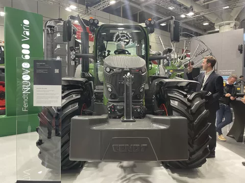 Ein Fendt 620 Vario DP mit Tractor of the Year 2025 Logo auf der Frontscheibe frontal fotografiert, daneben ein Mann im Anzug der den Traktor fotografiert