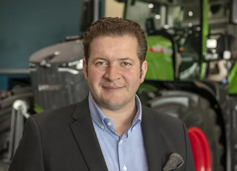Dr. Franz Dominic Esser (Director Sales Fendt EME) im Anzug vor einem Traktor