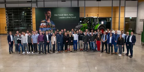 Fendt Mitarbeitende mit 10 Jahren Betriebszugehörigkeit gemeinsam mit der Fendt Geschäftsführung vor einem Fendt Traktor