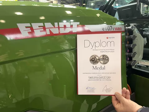 Diplom zur polnischen Goldmedaille für den Fendt e107 V Vario vor dem Fendt Traktor