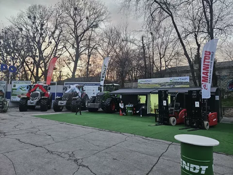 Ein Messestand mit 2 Traktoren links und zwei Gabelstaplern rechts