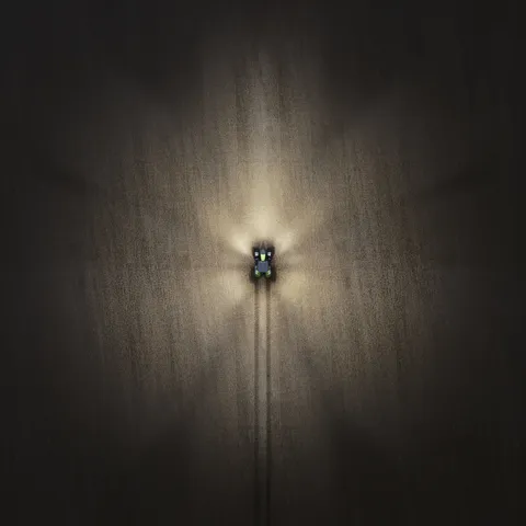 Drohnenaufnahme von einem Fendt 800 Vario in der Nacht mit eingeschalteten Lichtern.