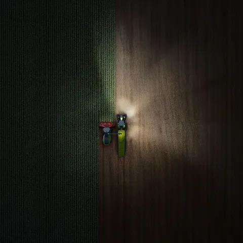 Drohnenaufnahme von einem Fendt 800 Vario in der Nacht mit eingeschalteten Lichtern - rechts.