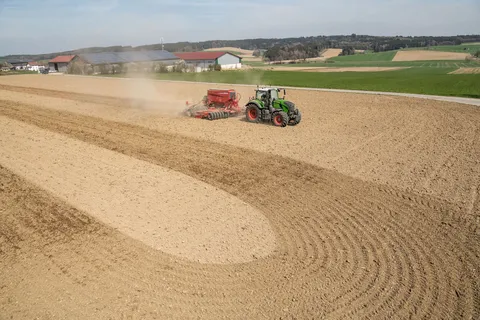 Ein grüner Fendt 724 Vario Gen7.1 fährt mit einer roten Drillmaschine von Horsch über einen Acker. Im Vordergrund ist ein enger Wendekreis zu sehen.