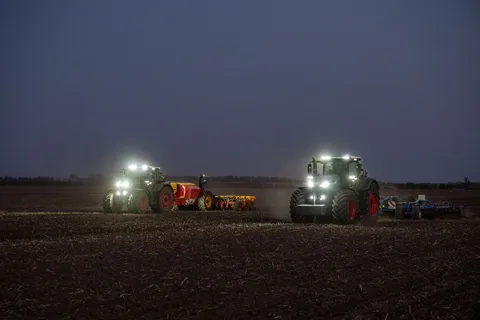 Ein grüner Fendt 1000 Vario mit Grubber und ein grüner Fendt 800 Vario mit Sämaschine von Väderstad arbeiten gemeinsam auf einem Feld. Die Zusammenarbeit funktioniert über den Datenaustausch in der FendtONE Funktion  Fendt Workgroup.
