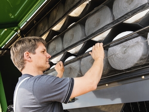 Detailaufnahme Fendt Quaderballenpresse bei der Bedienung durch Servicetechniker