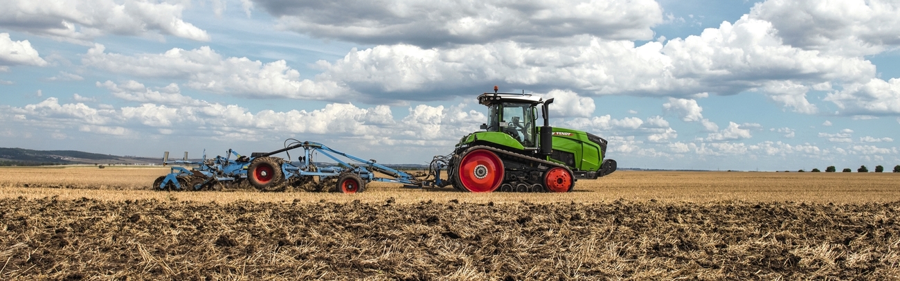 Raupentraktor Fendt 900 Vario MT mit blauer Scheibenegge auf einem Feld