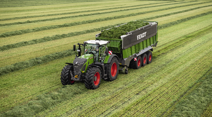 Fendt Tigo Ladewagen mit Fendt 900 Vario Traktor auf einer Wiese.