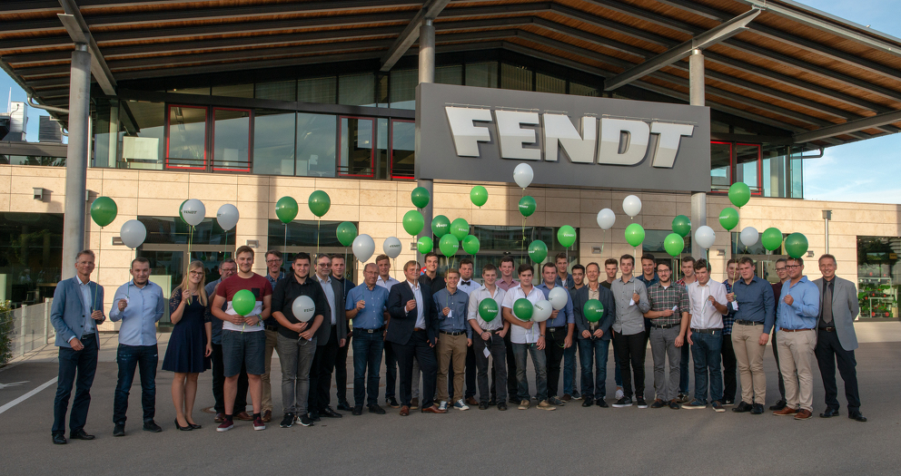 Ausbilder und Auszubildende lassen gemeinsam Luftballons vor dem Fendt Forum steigen