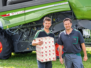 Fendt Mitarbeiter stehen vor einem Mähdrescher