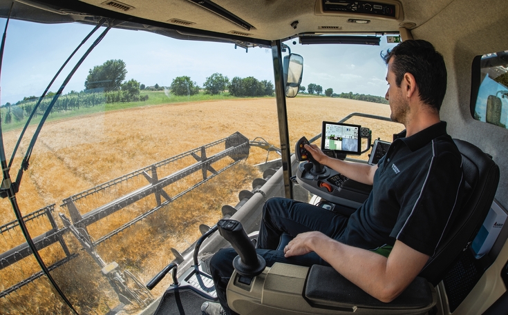 Landwirt in der Fahrerkabine mit dem neuen Lenksystem IDEALdrive