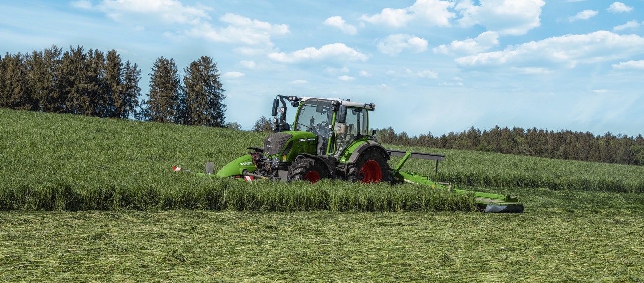 Fendt 300 Vario mäht mit einem Fendt Slicer eine Wiese.