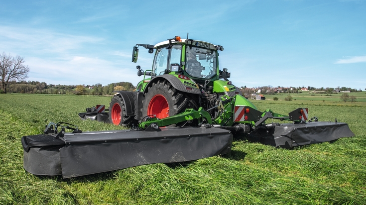 Fendt 516 Vario mit Fendt Slicer 860 und Frontmähwerkanbau mäht bei schönem Wetter eine Wiese