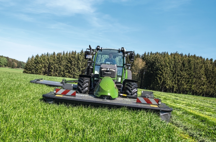 Fendt 516 Vario mit Fendt Slicer 310 F und Heckmähwerkanbau mäht bei schönem Wetter eine Wiese