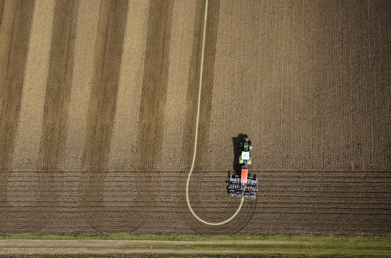 Obersicht Fendt 900 Vario bearbeitet Feld mit Anbaugerät in sehr geraden Spuren